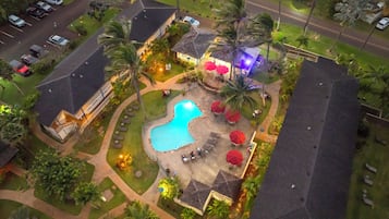 Una piscina al aire libre, sillones reclinables de piscina