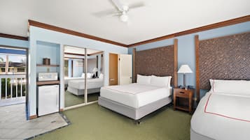 A hotel room with a bed, a desk, a chair, a microwave, and a refrigerator.