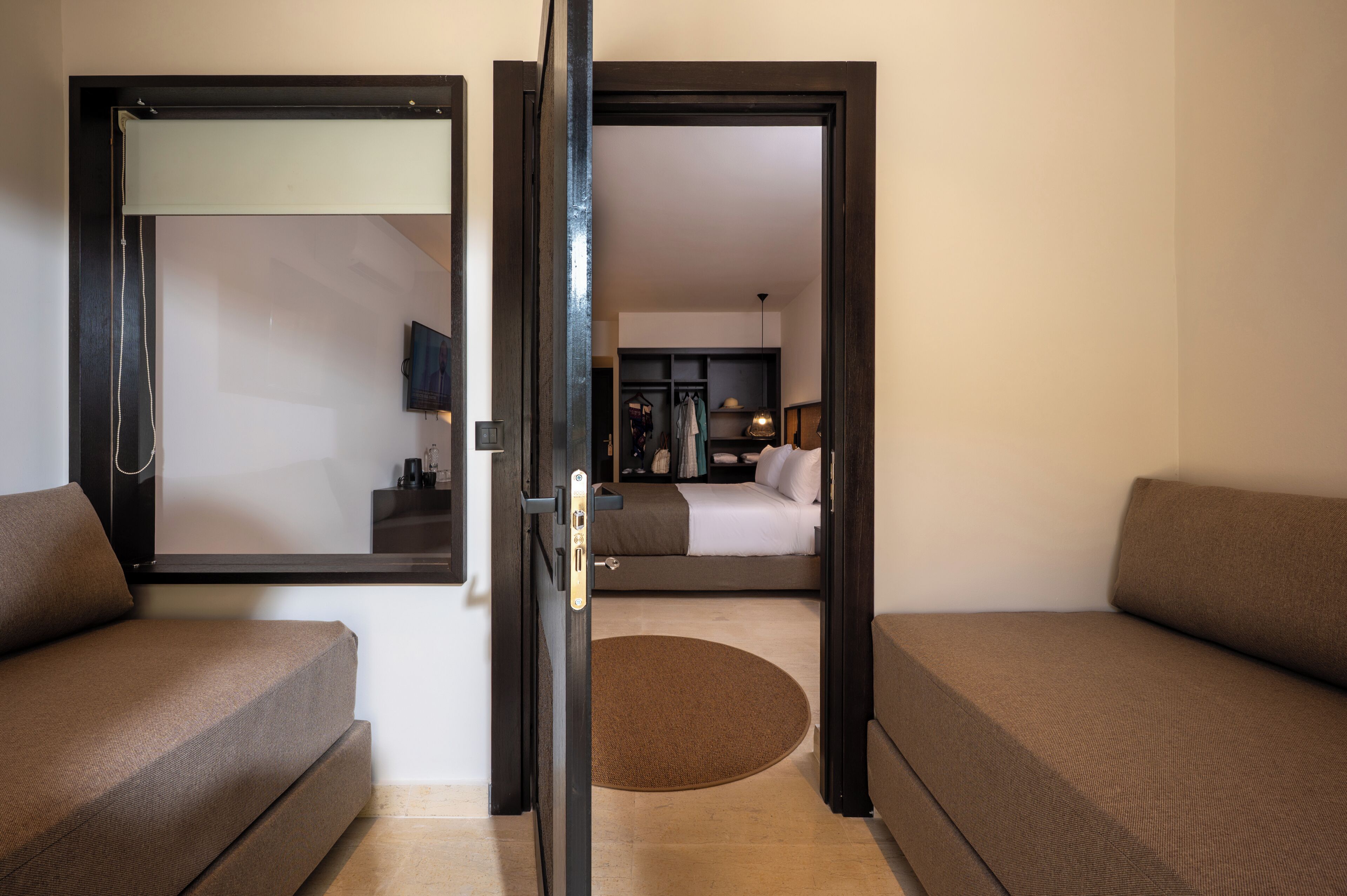 A hotel room with a bed, a desk, a chair, and a television.