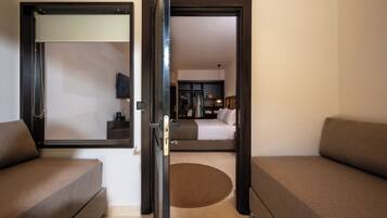 A hotel room with a bed, a desk, a chair, and a television.