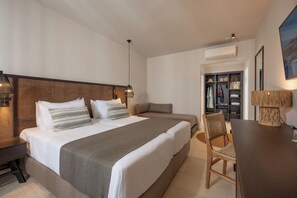 Hotellihuone, jossa on suuri sänky, yöpöydät, työpöytä, tuoli ja vaatekaappi.