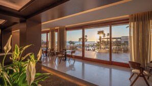 Un moderno vestíbulo de hotel con un amplio ventanal, un mostrador de recepción y zona de estar.