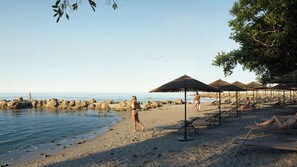 Pantai di sekitar, kursi berjemur, payung pantai, dan handuk pantai