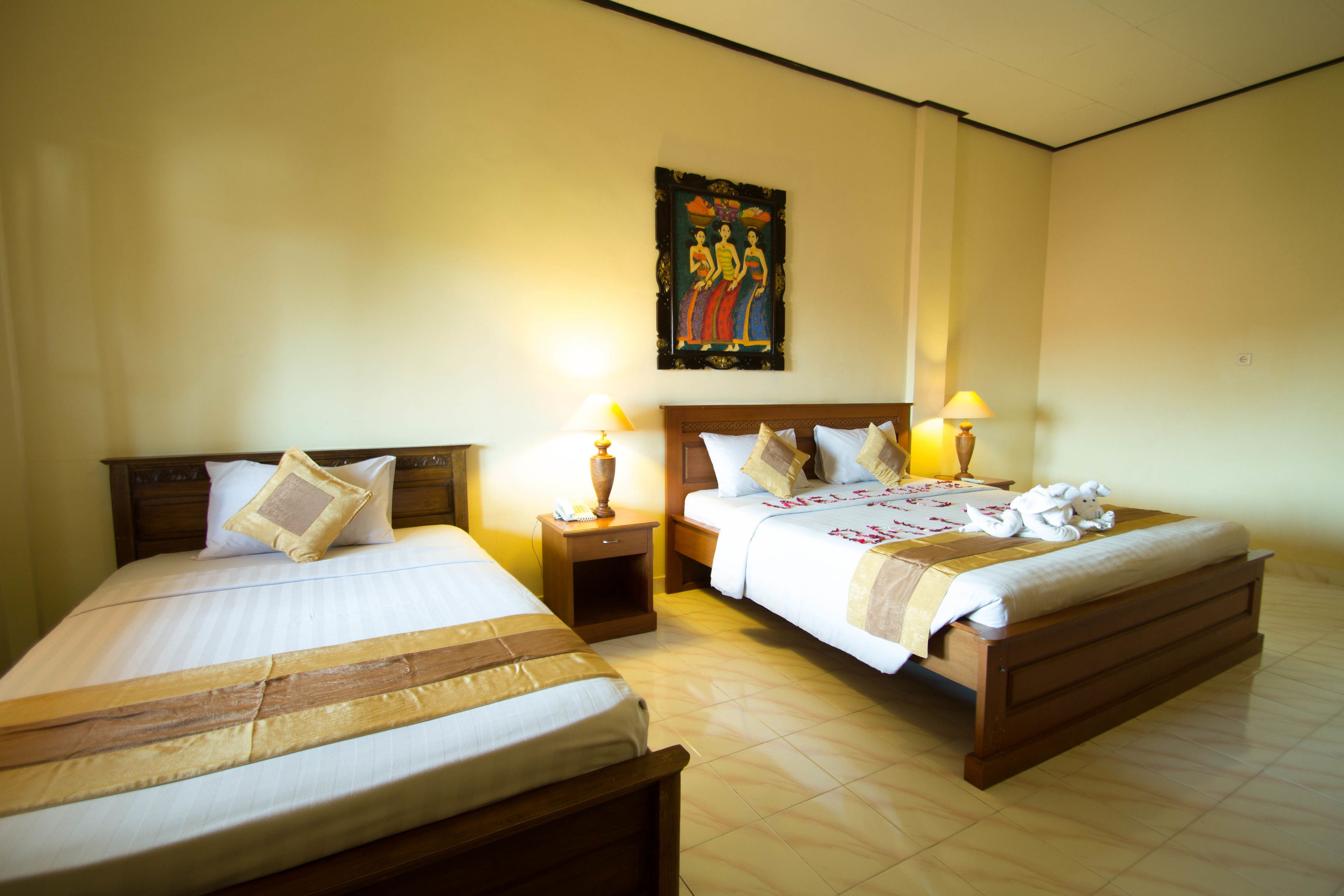A hotel room with two beds, wooden headboards, and bedside lamps.