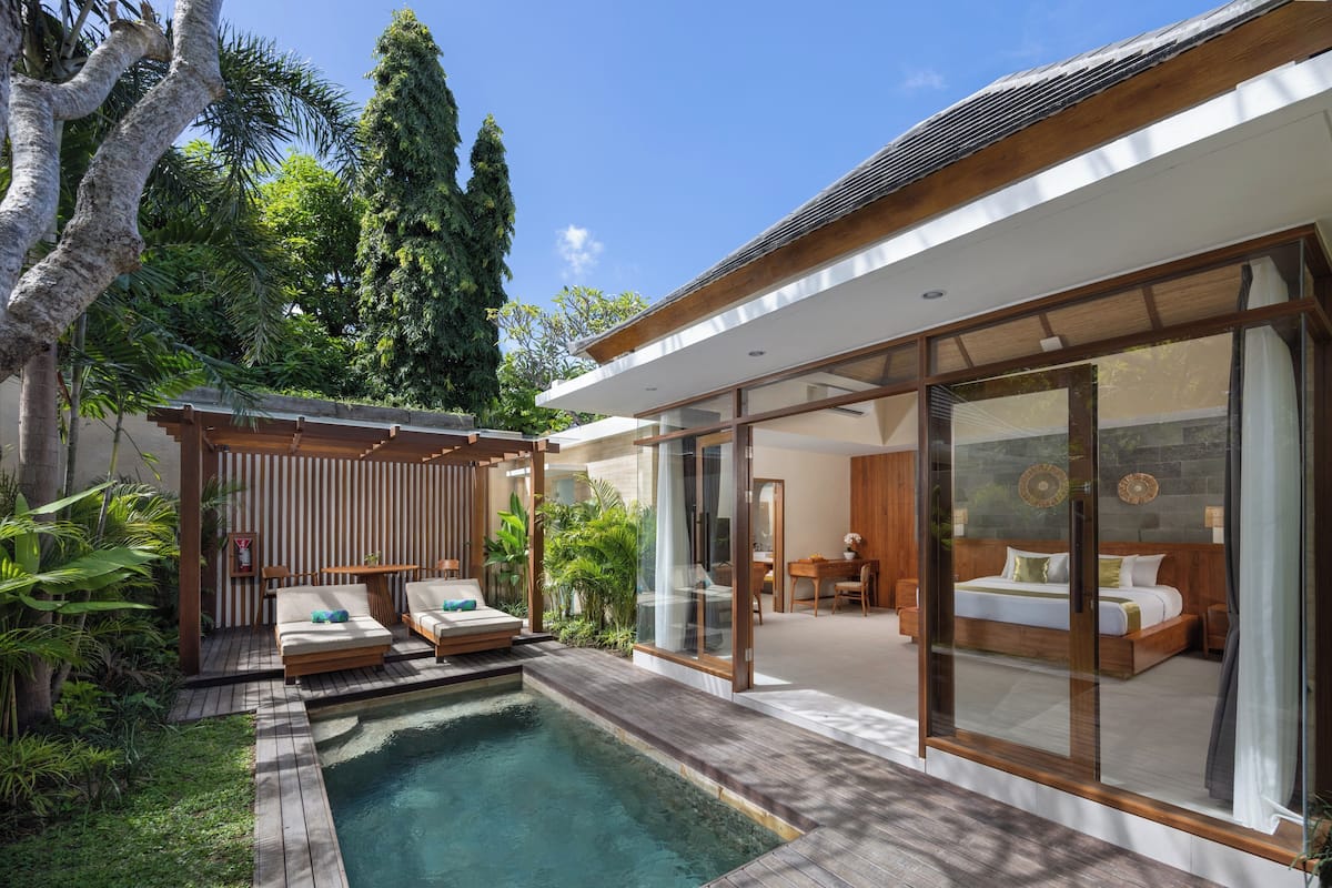 A modern villa with a swimming pool, a bedroom with a large bed, and a dining area.