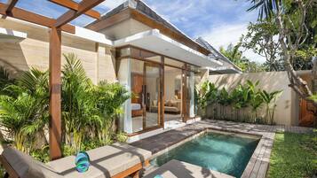 Una piscina al aire libre, sombrillas, sillones reclinables de piscina