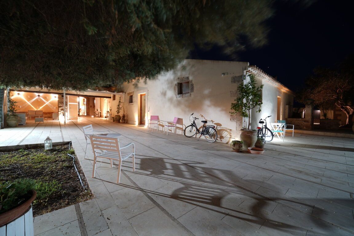 An outdoor area with a patio, seating, and bicycles.