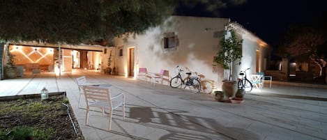 Un espacio exterior con patio, asientos y bicicletas.