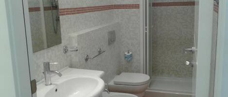Ein Badezimmer mit Waschbecken, Toilette und Dusche.