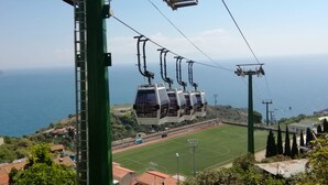 A cable car system with a view of the sea and a sports field below. - Villa Oasis Residence (Taormina)