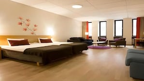 A hotel room with two beds, a sofa, a TV, and a desk. - Sky Hotel Malmö City (Malmö)