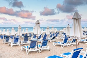 A beach with rows of white lounge chairs and umbrellas, arranged in a neat pattern. - Sol Luna Bay Resort (Byala)