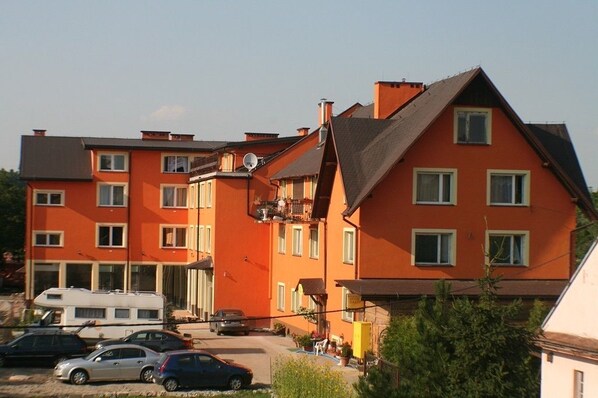 Un edificio residencial de varios pisos con fachada roja, múltiples ventanas y balcones.
