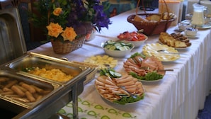A buffet table with various food items and a decorative centerpiece. - Hotel Daisy Superior (Kraków)