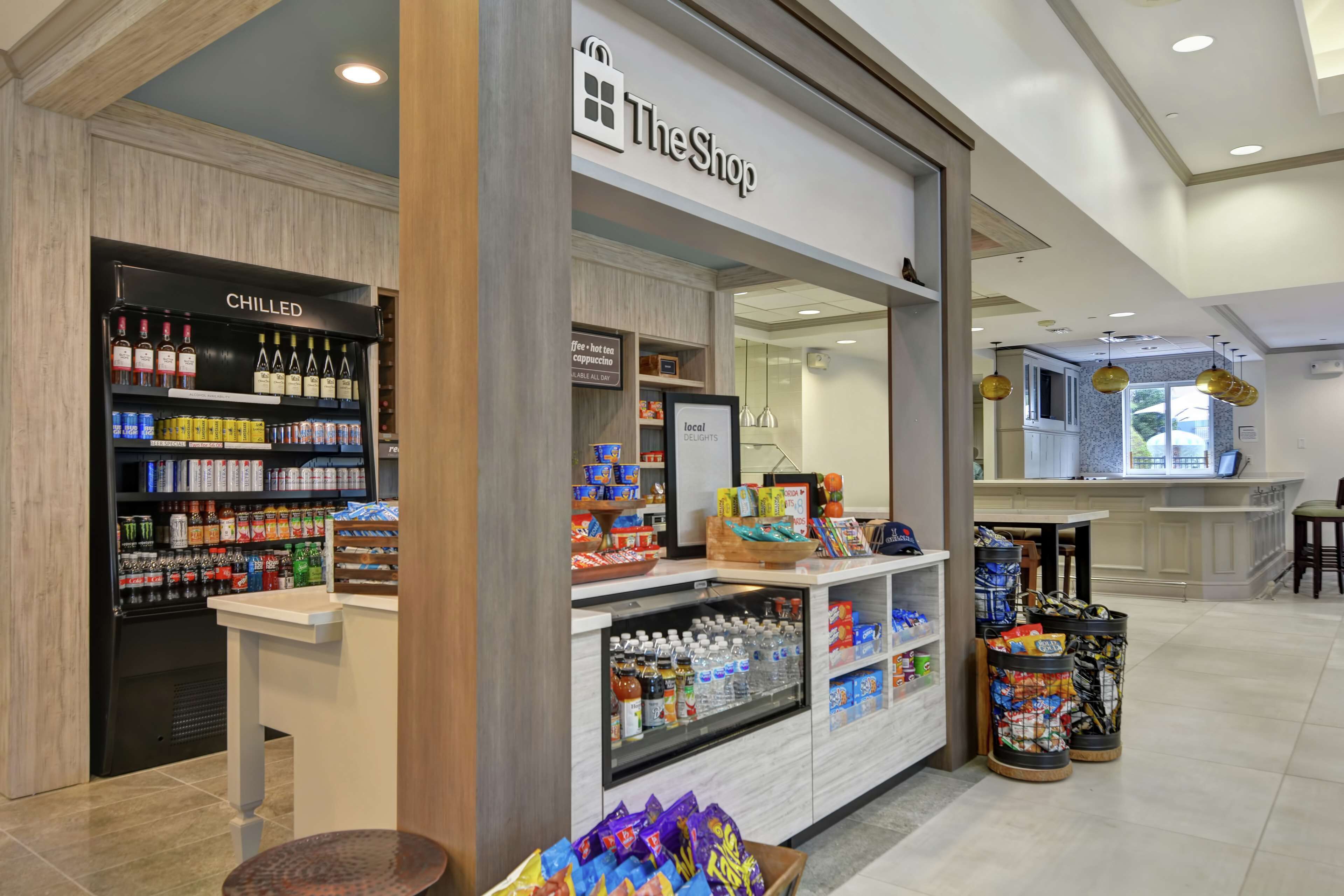 Ein Geschäft namens 'The Shop' mit gekühlten Getränken, Snacks und abgefülltem Wasser.