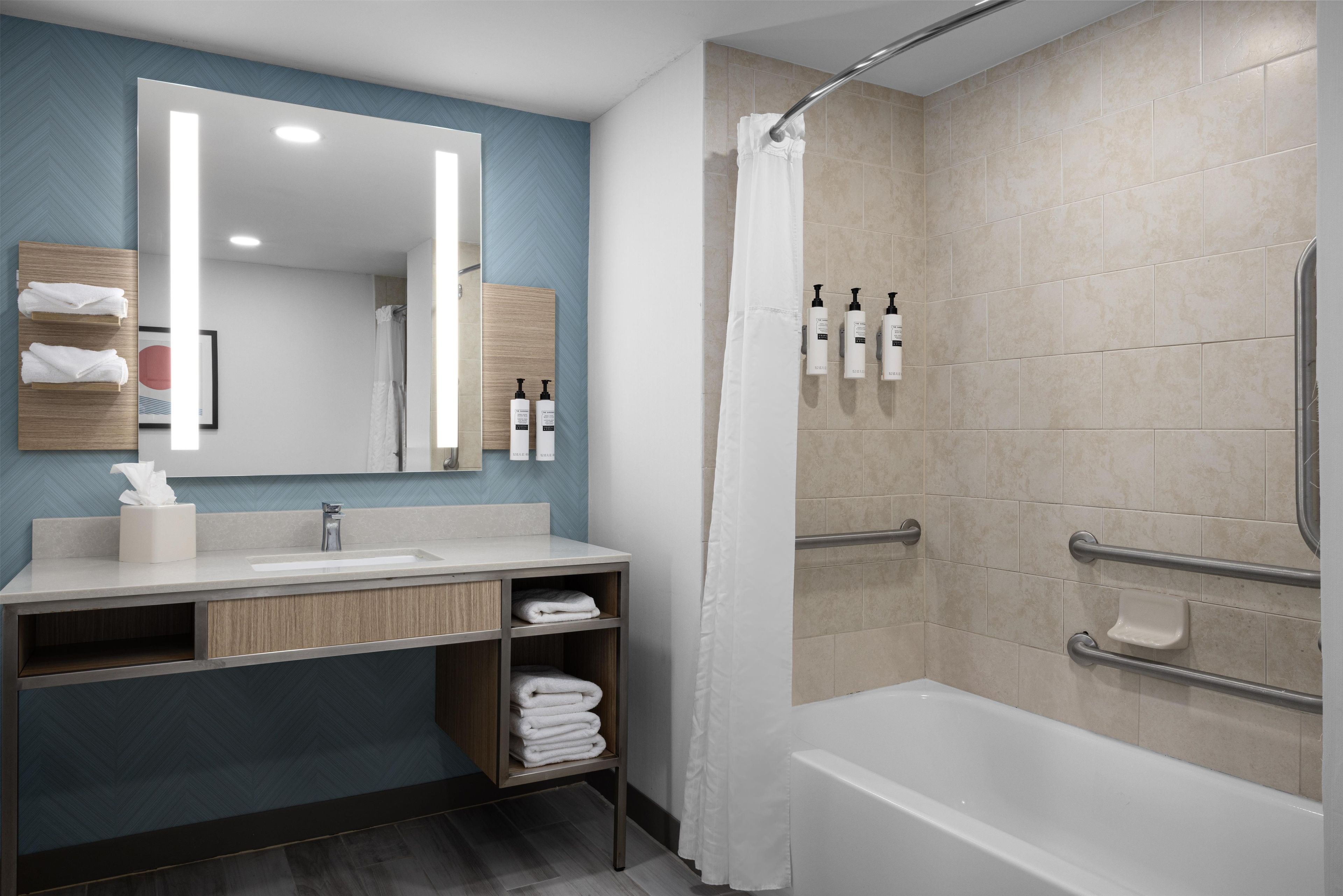 A modern bathroom with a shower, a sink, and a vanity.