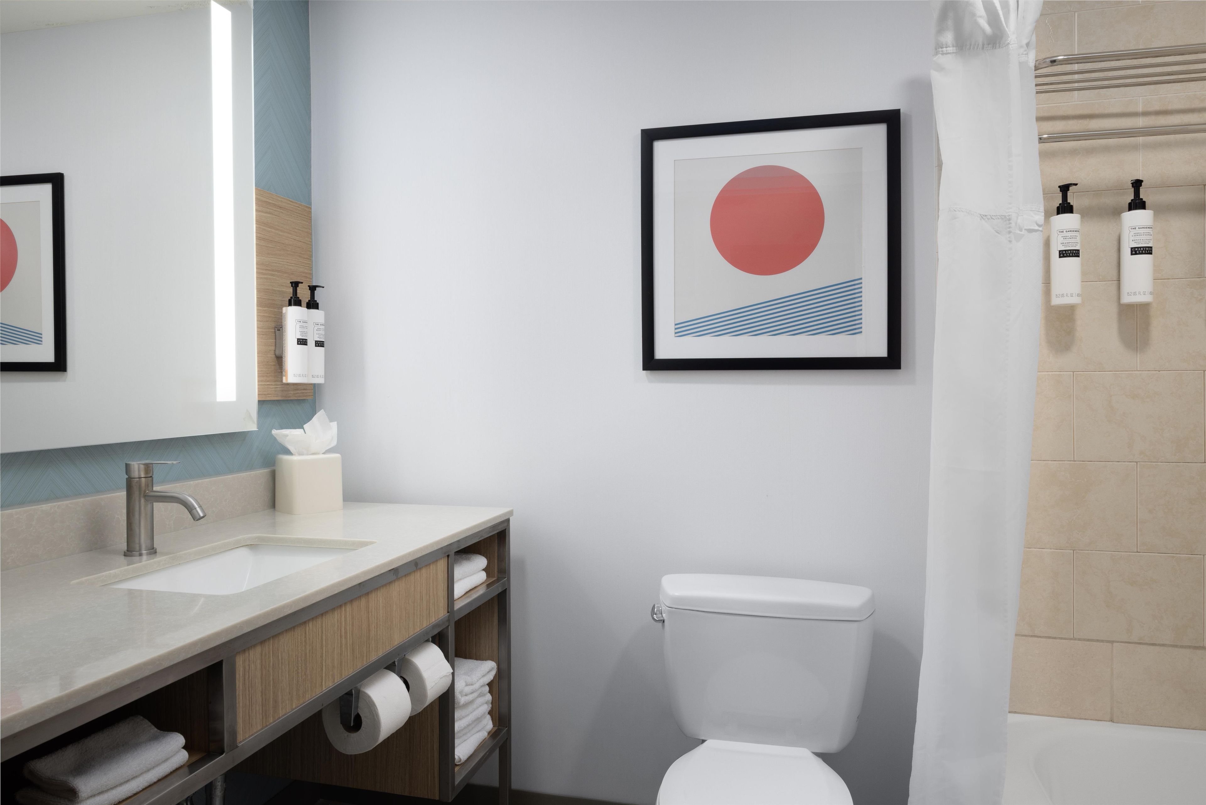 Un baño moderno con inodoro, lavabo y zona de ducha.