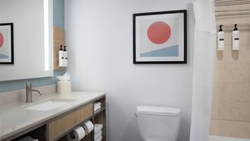 Un baño moderno con inodoro, lavabo y zona de ducha.