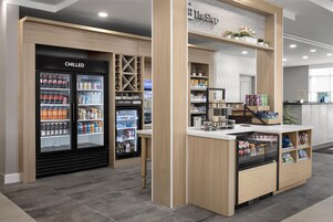Un quiosco de autoservicio con bebidas frías y congeladas, aperitivos y una variedad de productos envasados.
