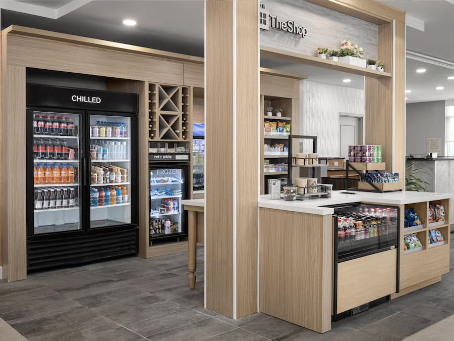 A self-service kiosk with chilled and frozen beverages, snacks, and a variety of packaged goods.