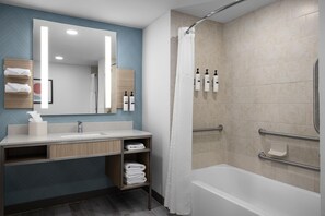 A modern bathroom with a shower, a sink, and a vanity.