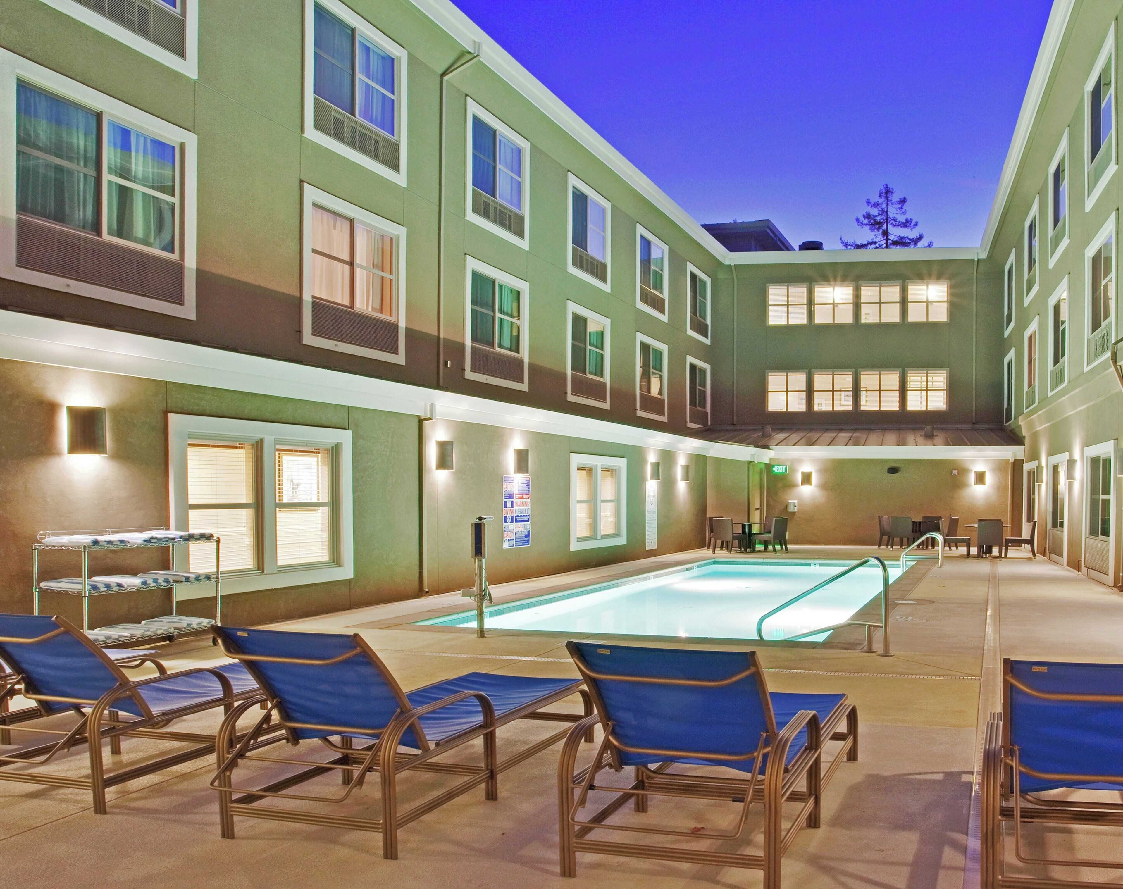 A poolside area with lounge chairs and a swimming pool.