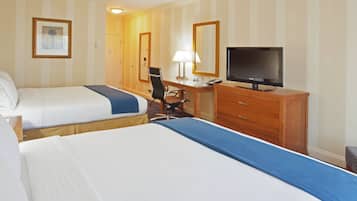 Une chambre d’hôtel avec deux lits, un bureau avec une chaise, une télévision et un miroir.