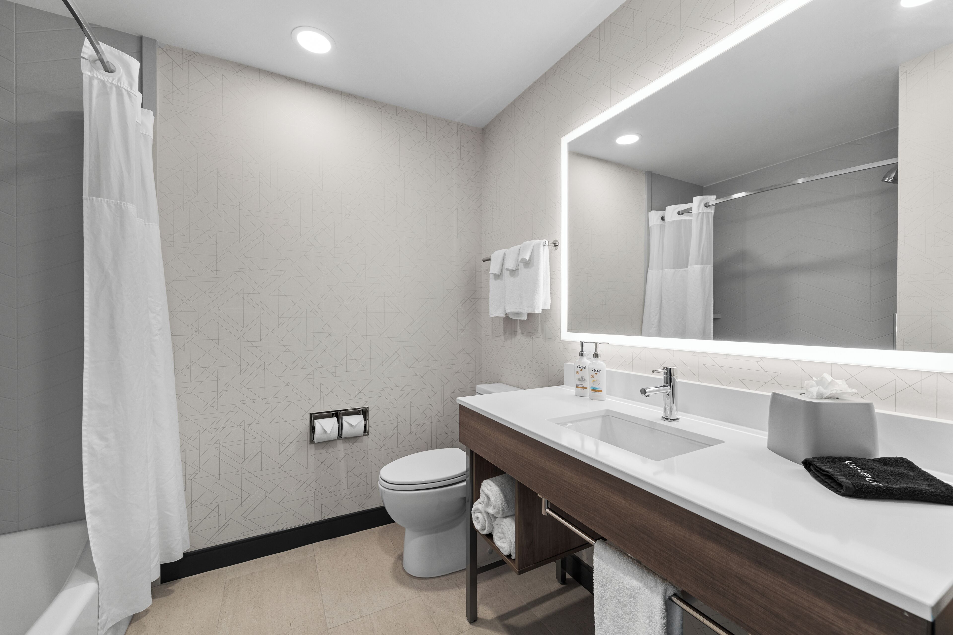 A modern bathroom with a shower, toilet, and vanity.