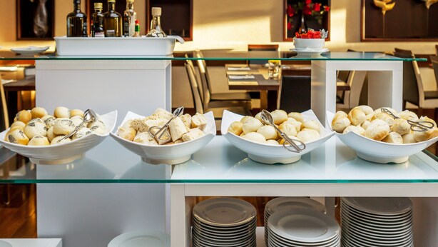 Ein reichhaltiges Buffet mit verschiedenen Schalen für Speisen und Beilagen auf einer Glastheke.