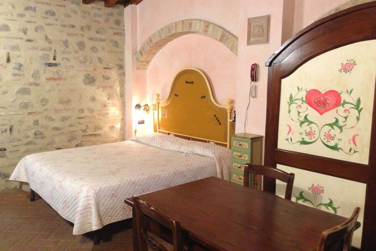 Ein Schlafzimmer mit einem Bett, einem Holztisch und Stühlen.