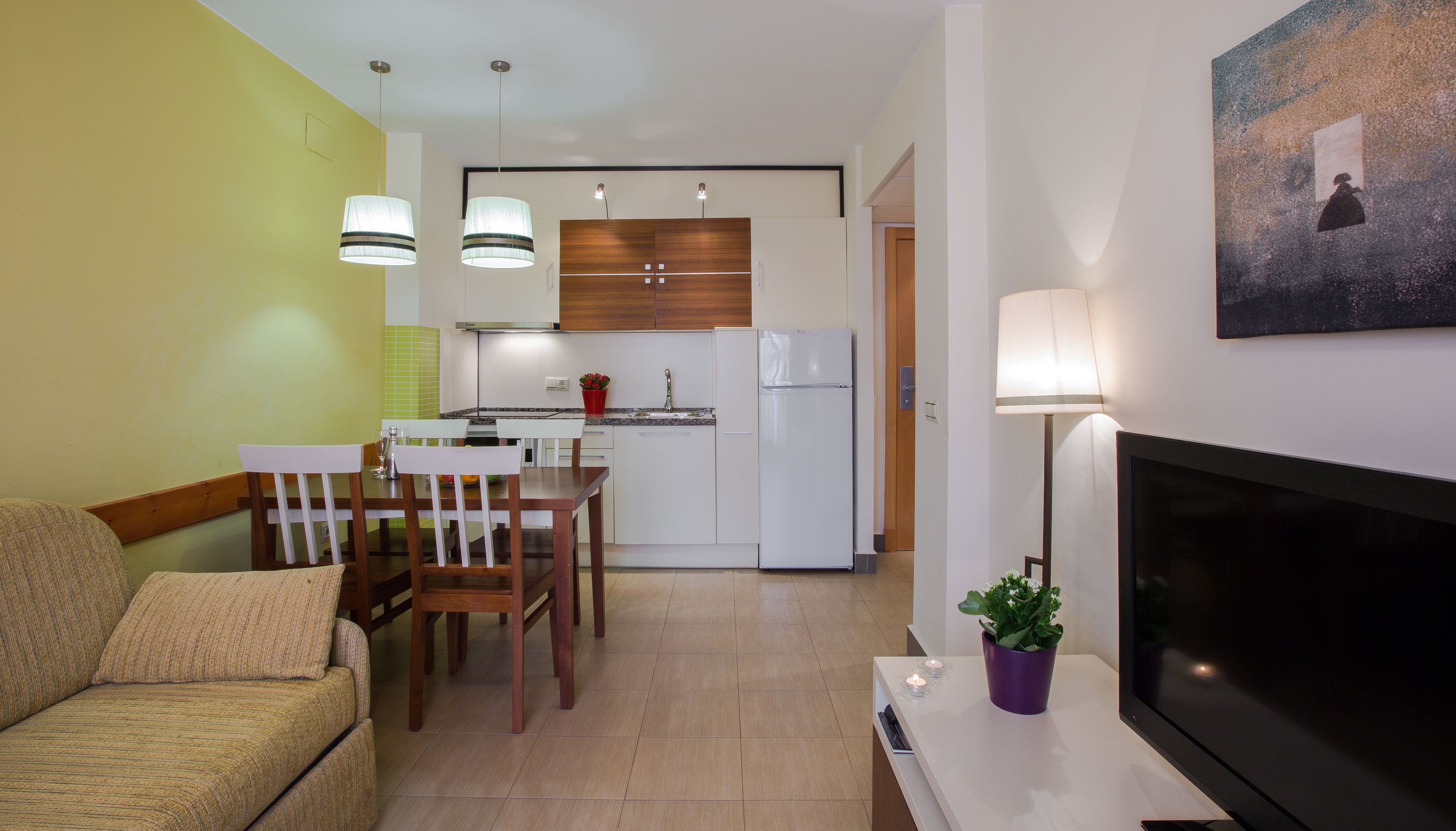 A modern apartment with a dining area, kitchen, and living room.