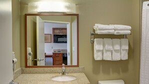 A bathroom with a sink, mirror, and towel rack.