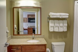 Une salle de bain avec un lavabo, un miroir et un porte-serviettes.
