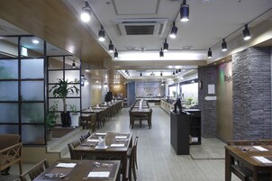 Un restaurante con varias mesas, sillas y una barra.