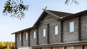 A log cabin with a gabled roof and multiple windows. - Dalhall Hotell (Åmål)
