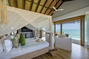 Una habitación con cama, televisión y vista al océano.