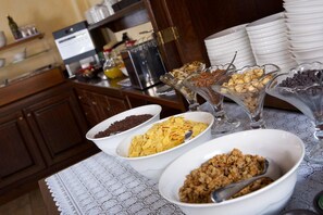 A breakfast buffet with various cereals and toppings in bowls. - Hotel L'aiglon (Ayas)
