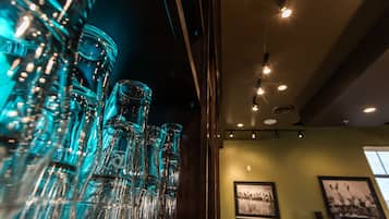 A bar area with multiple glass bottles and a framed picture on the wall.