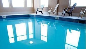 Une piscine intérieure à l’eau d’un bleu cristallin, dotée de couloirs délimités et de grandes fenêtres baignées de lumière.