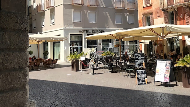 Un hotel llamado HOTEL EUROPA con terraza y una plaza adoquinada.