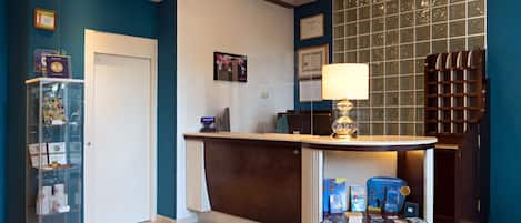 A reception area with a wooden reception desk, a glass display case, and a wall-mounted air conditioning unit.