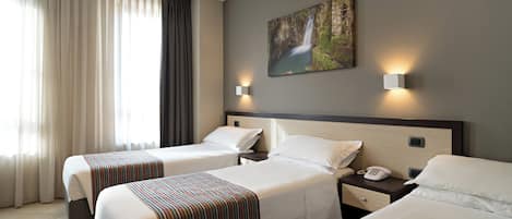 A hotel room with two beds, a painting on the wall, and a window with curtains.
