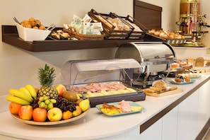A buffet with a variety of food items including fruits, meats, and pastries. - Hotel Spinelli (Viareggio)