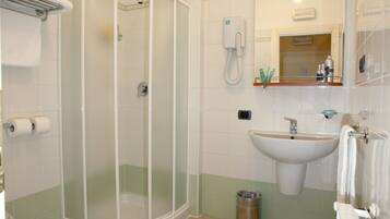A bathroom with a shower, sink, and toilet.