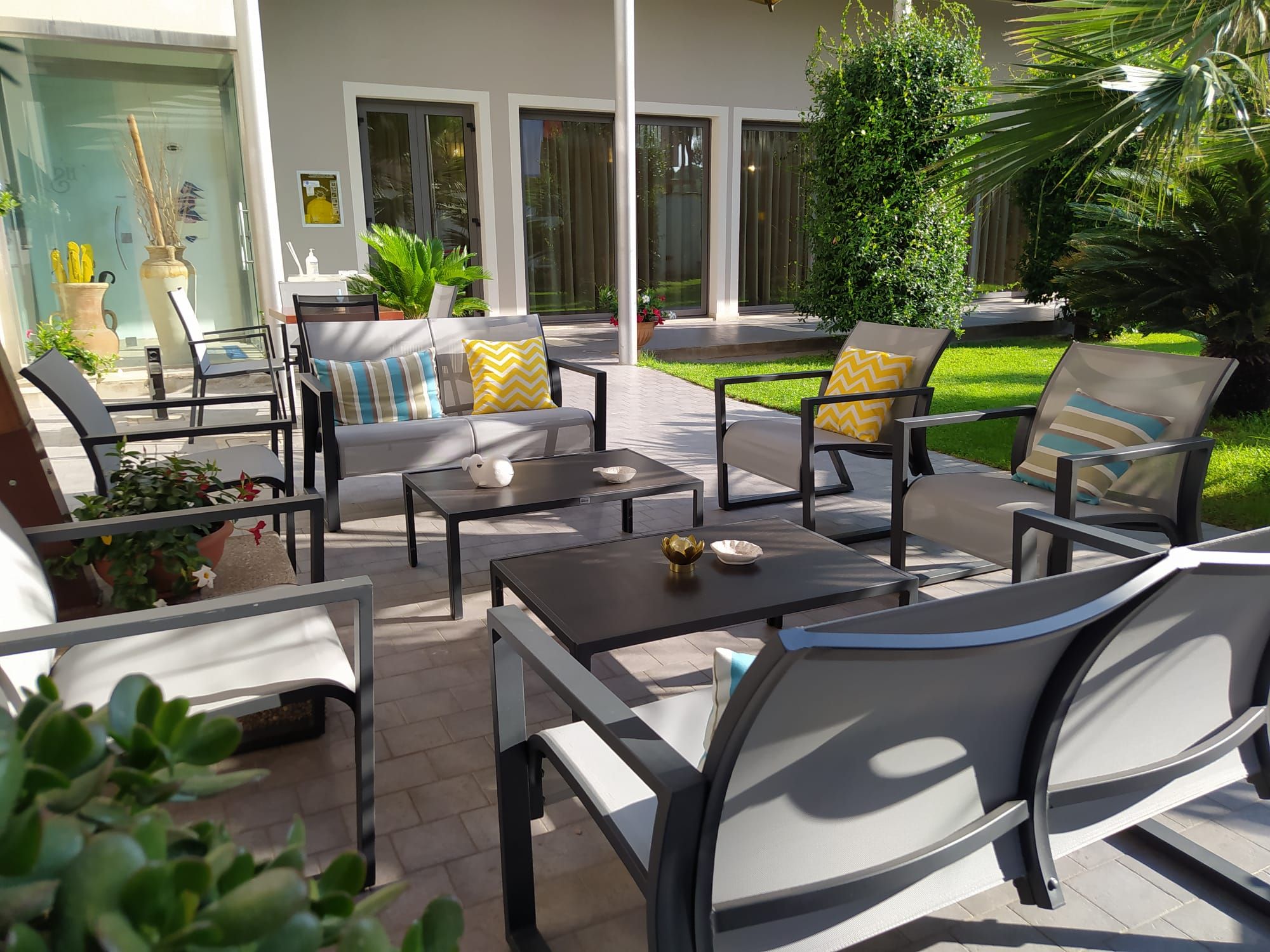 An outdoor patio area with multiple seating options, including sofas and chairs, arranged around tables.