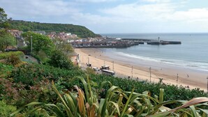 A coastal town with a beach, a pier, and lush greenery. - The Clifton Hotel (Scarborough)