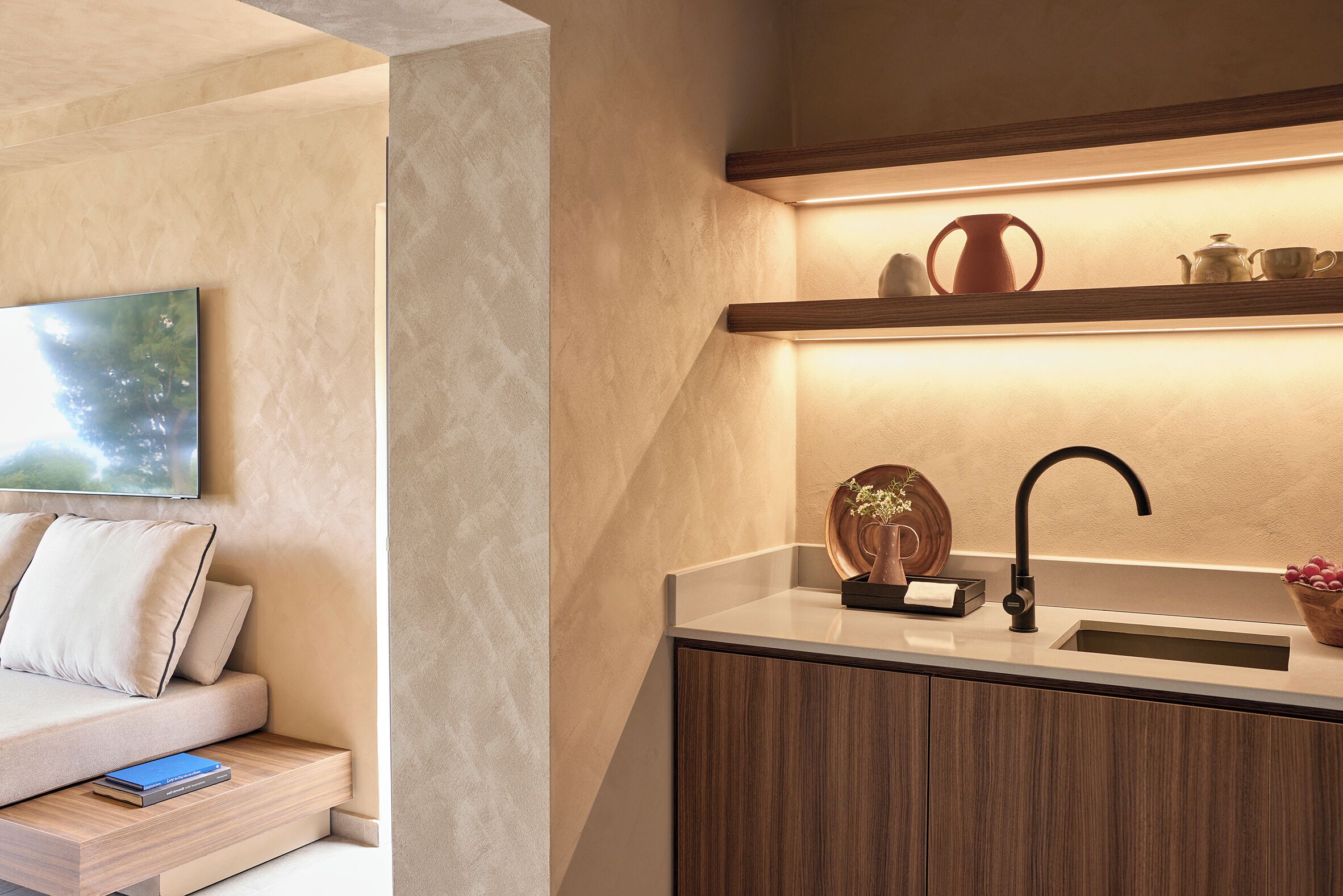 Una cocina moderna con encimera de madera, un lavamanos y una estantería sobre la encimera con utensilios de cocina.