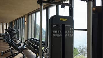 A gym with exercise equipment, large windows, and a view of the outdoors.