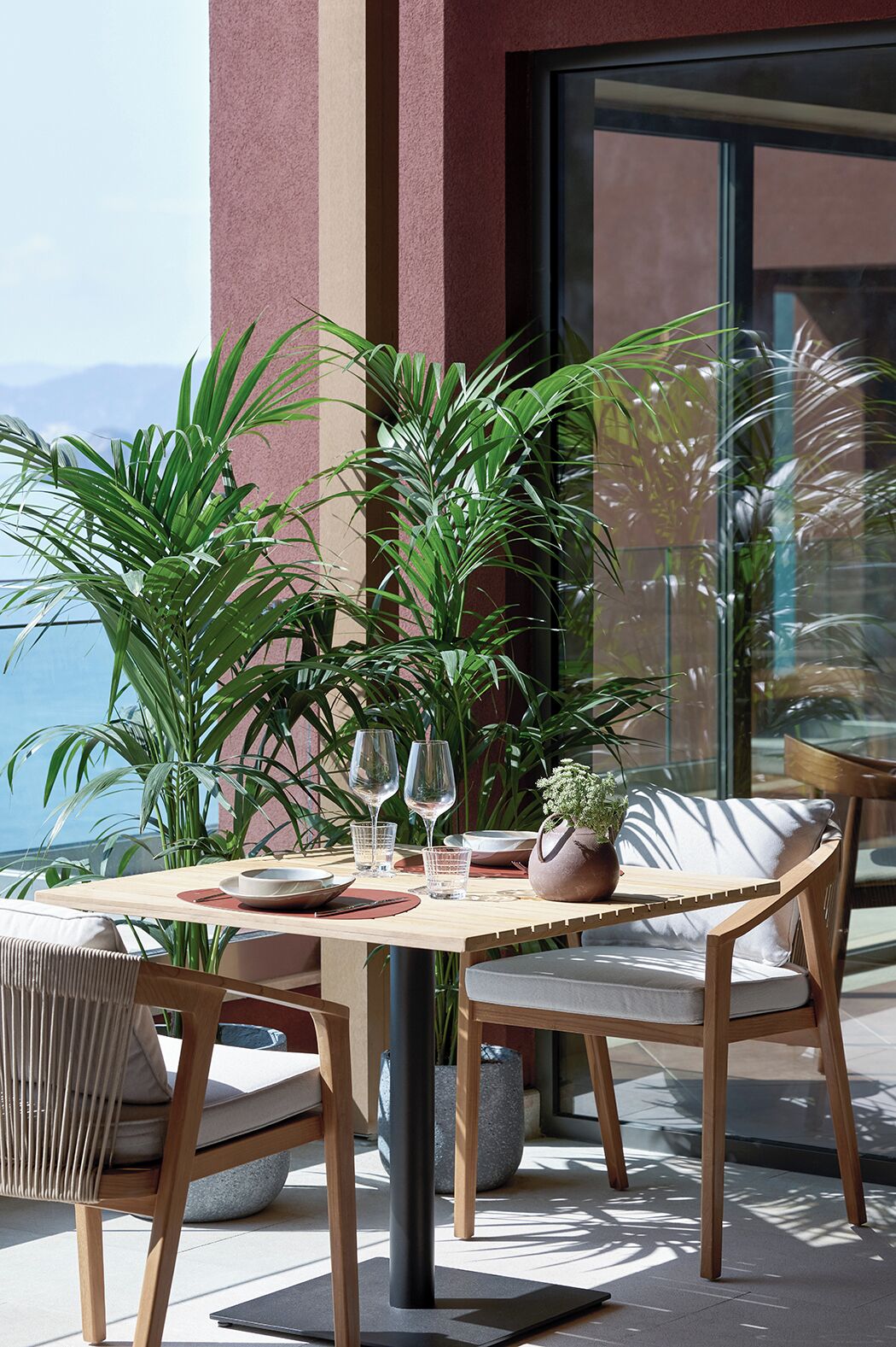 Une table en bois, des chaises, un vase et un bol.