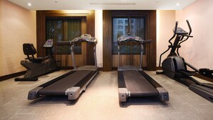 Une salle de sport équipée de deux tapis de course, d’un vélo d’appartement et d’un rameur.